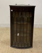A Georgian mahogany bow front corner cabinet, with arcaded frieze over astragal glazed door