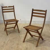 A pair of slatted teak folding garden chairs, H82cm