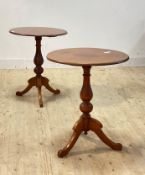 A pair of Victorian walnut and pine lamp tables, the circular tops raised on baluster columns and