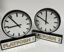 A pair of modern Platform 1 and Platform 2 quartz circular dial free standing clocks with baton hour