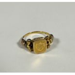 A 19thc yellow metal ring, the centre panel with shield shape design with engraved initials A C R,