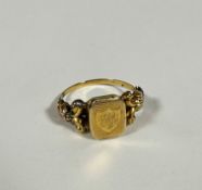 A 19thc yellow metal ring, the centre panel with shield shape design with engraved initials A C R,
