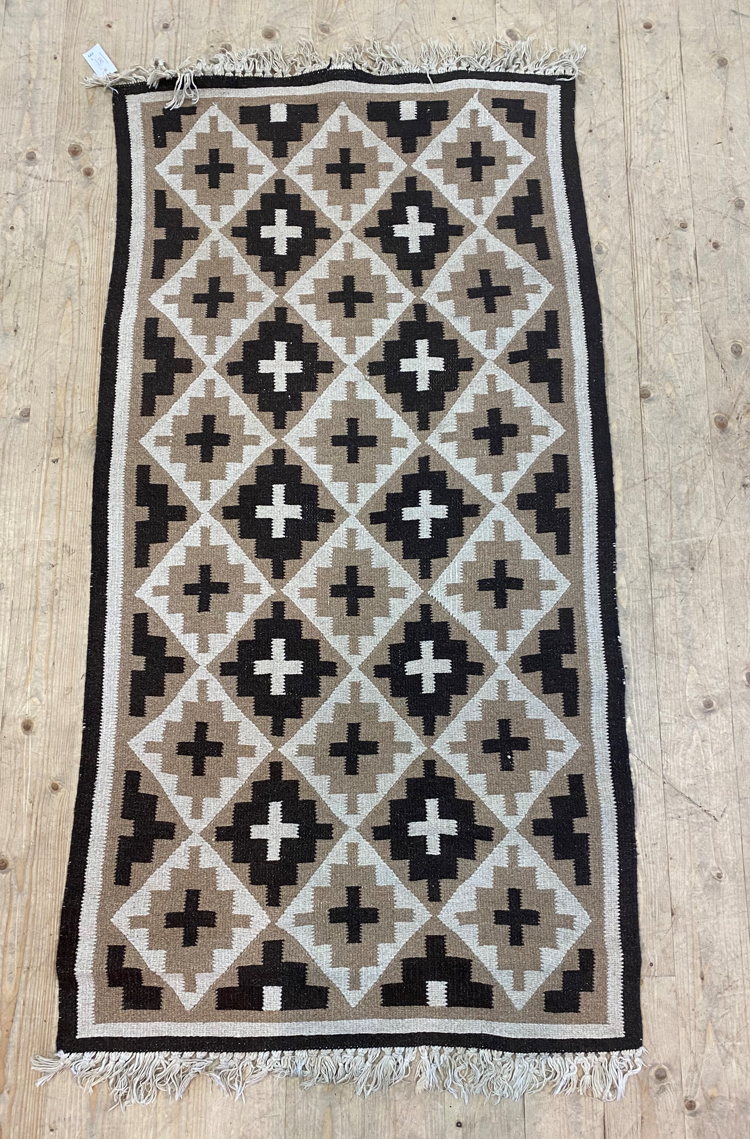 A North African flat weave rug, of repeating lozenge design, 176cm x 85cm