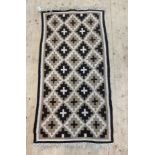 A North African flat weave rug, of repeating lozenge design, 176cm x 85cm