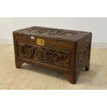 A Chinese camphor wood blanket box, each side with typical relief carvings, the hinged lid lifting