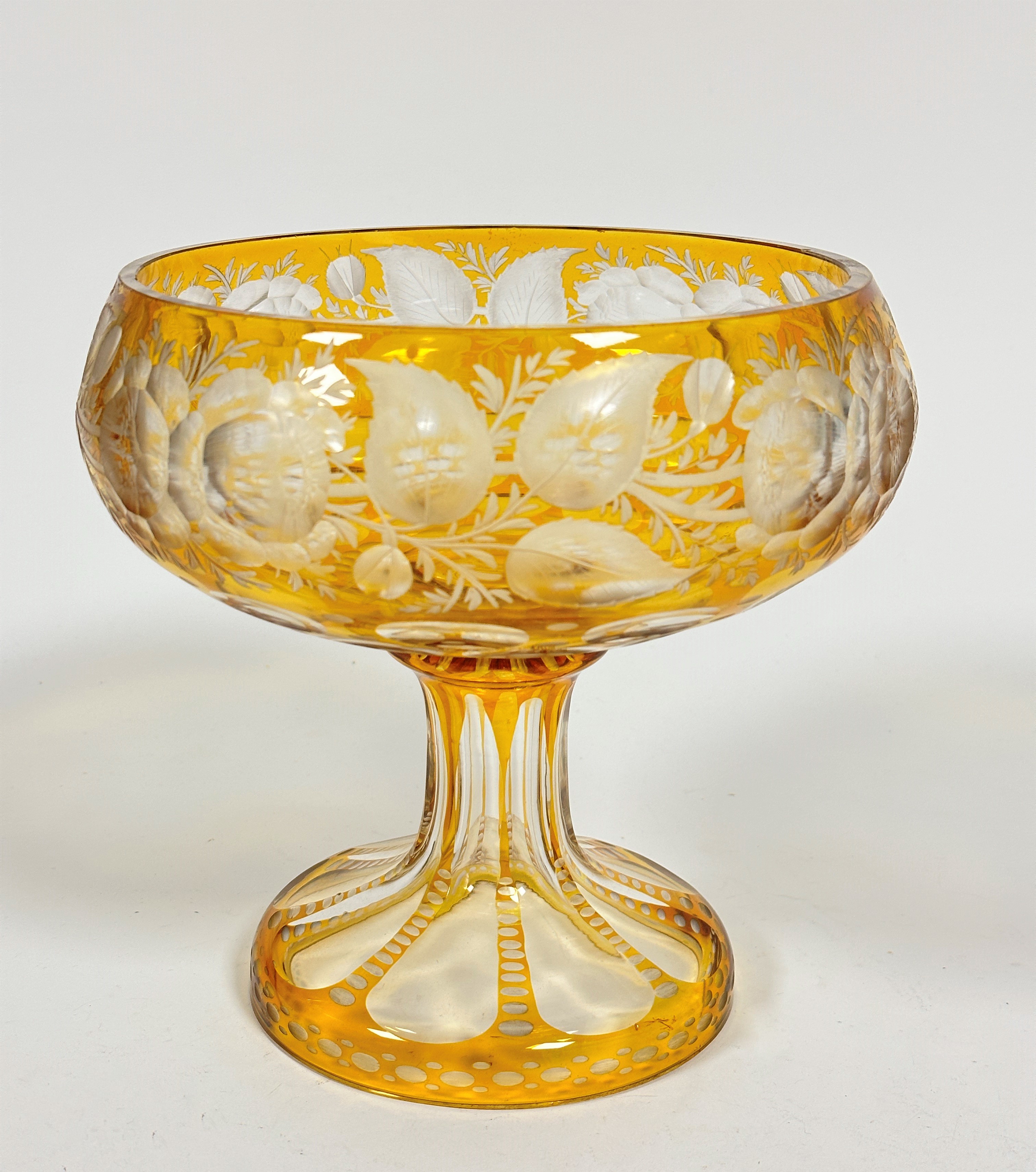 A large amber to clear slice cut fruit bowl with stylised flowers, leaves and panels, on faceted cut
