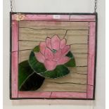 A stained and lead glazed window panel, the centre depicting a water lily 50cm x 51cm