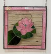 A stained and lead glazed window panel, the centre depicting a water lily 50cm x 51cm