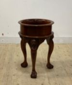 A mahogany table plant stand, the recessed top with flared rim over three lion masks and cabriole