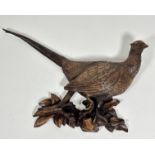 A modern resin moulded wall applique of a cock pheasant, raised on naturalistic style moulded leaf