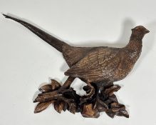 A modern resin moulded wall applique of a cock pheasant, raised on naturalistic style moulded leaf