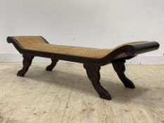 A carved hardwood scroll end window bench of Regency design wiyth overstuffed split cane covered