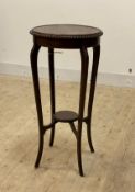 An Edwardian mahogany jardiniere stand, the circular gadrooned top over splayed supports united by