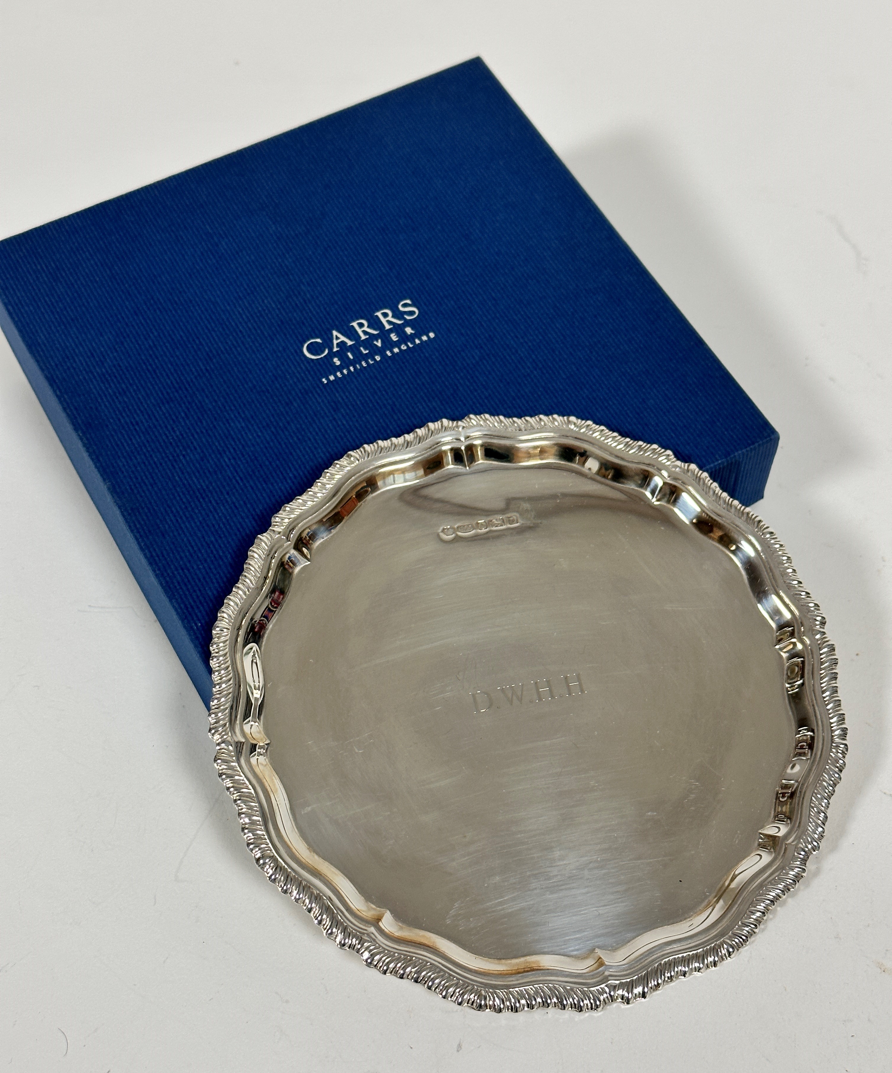 A modern silver scalloped Georgian style card waiter with engraved initials DWHH, stamped 925 and