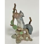 A Spanish Lladro porcelain grey squirrel on a cherry tree, decorated with polychrome enamels, signed