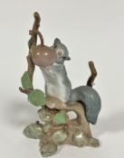 A Spanish Lladro porcelain grey squirrel on a cherry tree, decorated with polychrome enamels, signed