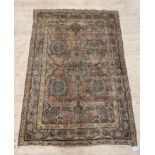 A Persian style rug, the faded red field decorated with lotus heads and bordered 200cm x 134cm