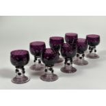 A set of eight amethyst glass roemers, possibly Murano, each dimpled cup bowl on a hollow prunted