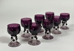 A set of eight amethyst glass roemers, possibly Murano, each dimpled cup bowl on a hollow prunted