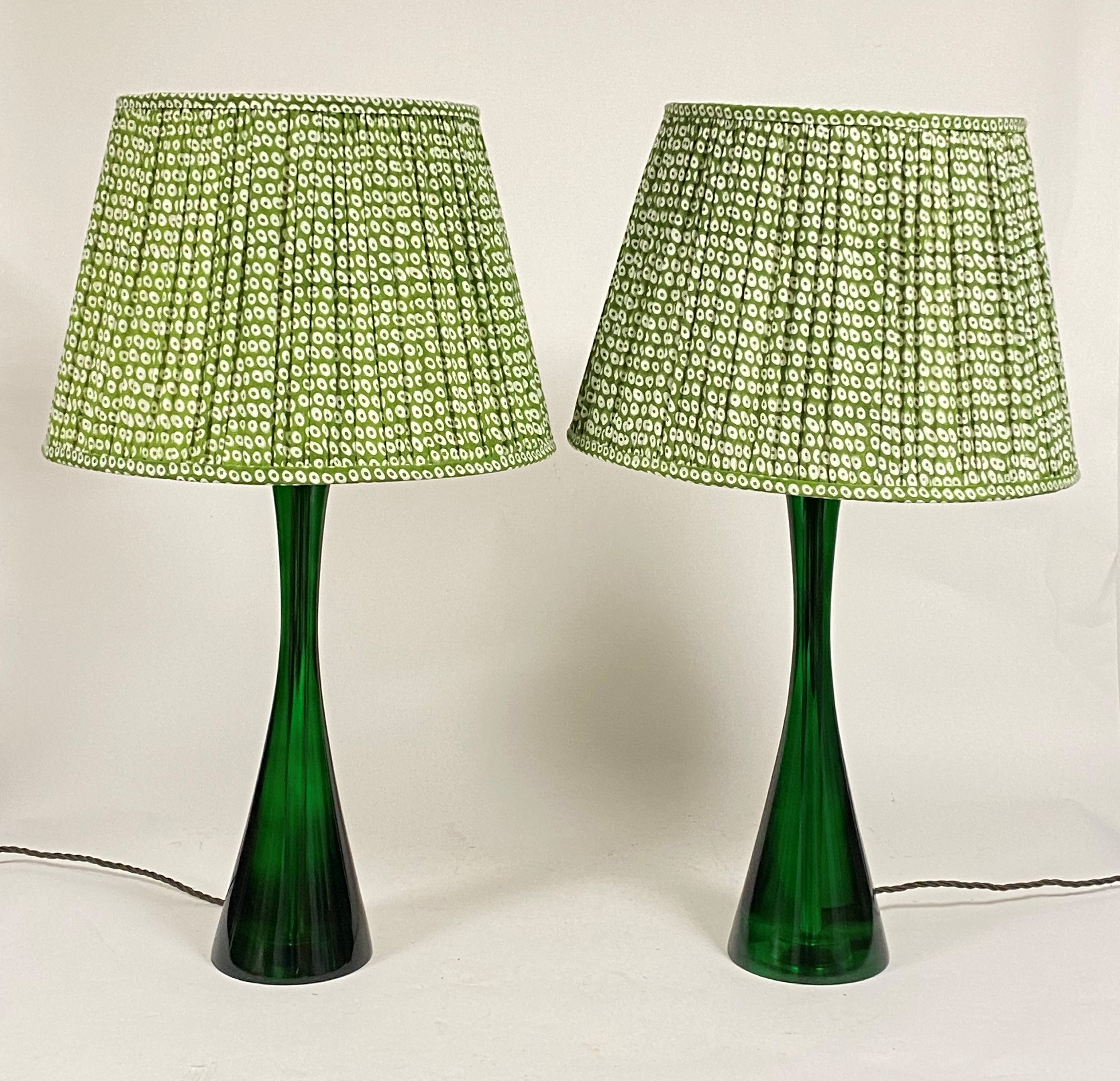 A pair of green resin table lamps, of waisted form, by Pooky Lighting, with green printed cotton