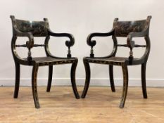 A pair of gilt and black lacquered elbow chairs of Regency design, circa 1920, the crest rail