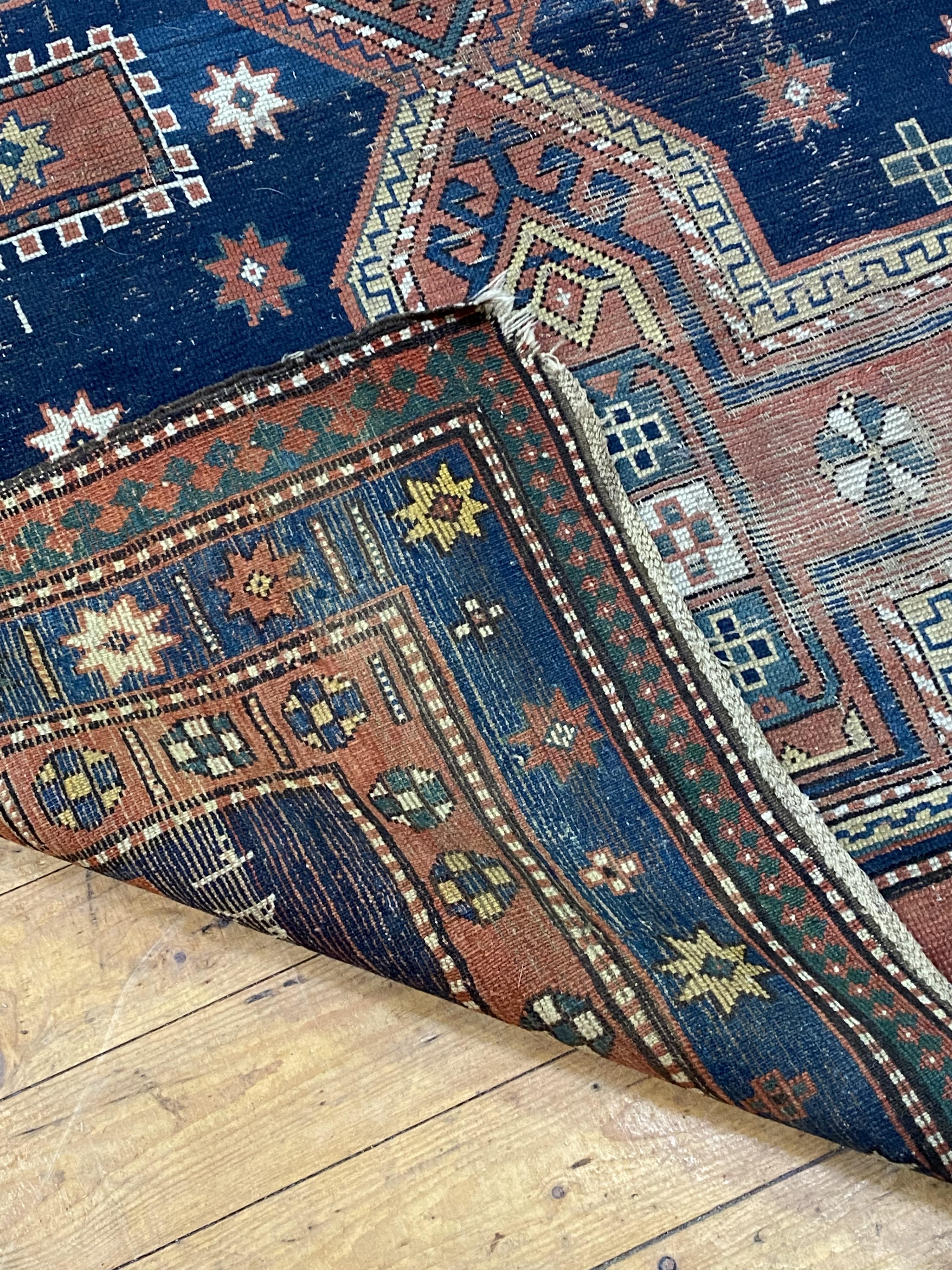 A hand knotted Caucasian Kazak rug, early 20th century, the blue field decorated with three
