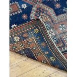 A hand knotted Caucasian Kazak rug, early 20th century, the blue field decorated with three