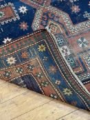 A hand knotted Caucasian Kazak rug, early 20th century, the blue field decorated with three