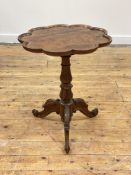 An early Victorian rosewood tripod table, the scalloped top with raised edge over a baluster