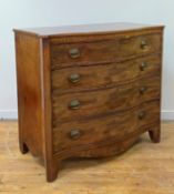 A Hepplewhite period mahogany chest of drawers of serpentine outline, the frieze inlaid with