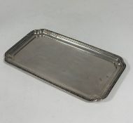 A white metal tray, early 20th century, of rectangular form, with floral trellis rim, stamped