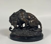 After Antoine Louis Barye (1795-1875), Lion au Serpent, a patinated bronze, on a slate plinth.