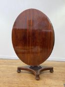 A William IV 4'6" rosewood dining table, the circular tilt top over a faceted octagonal column,