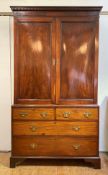 A George III mahogany linen press, the dentil cornice over twin panelled doors enclosing eight later