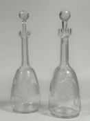 A pair of 19th century etched glass decanters, of mallet form, each with elongated faceted neck