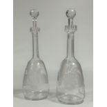 A pair of 19th century etched glass decanters, of mallet form, each with elongated faceted neck