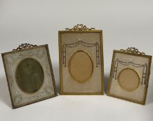 Three Edwardian gilt-metal and silk needlework photograph frames, of similar design, each with