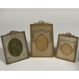 Three Edwardian gilt-metal and silk needlework photograph frames, of similar design, each with