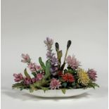 A striking German porcelain floral display, mid-20th century, the unmarked oval porcelain bowl