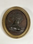 A 19th century bronze bas relief oval panel, probably French, depicting a profile bust of a lady