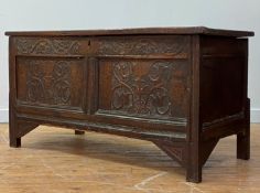 A 17th/early 18th century oak coffer, the panelled top opening to a plain interior, over twin