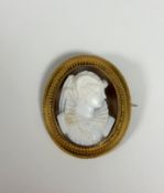 A 19th century yellow metal mounted shell cameo brooch, the oval cameo depicting a lady in 16th