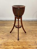 An Edwardian mahogany jardiniere stand in the Regency taste, the spun brass liner enclosed by