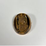 An unusual 19th century carved tiger's eye cameo brooch, oval, relief-carved with a portrait bust of