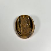 An unusual 19th century carved tiger's eye cameo brooch, oval, relief-carved with a portrait bust of