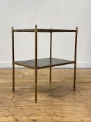 A mid-20th century two tier leather-inset brass occasional table, the cylindrical legs with acorn