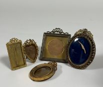 A group of small Edwardian gilt-metal photograph frames comprising: a square frame with ribbon-