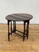 A late 18th century oak gateleg table, the oval hinged top over tapering columnar legs with blocks