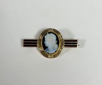 A 19th century carved agate cameo brooch, the central oval cameo carved with a Classical female