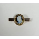 A 19th century carved agate cameo brooch, the central oval cameo carved with a Classical female